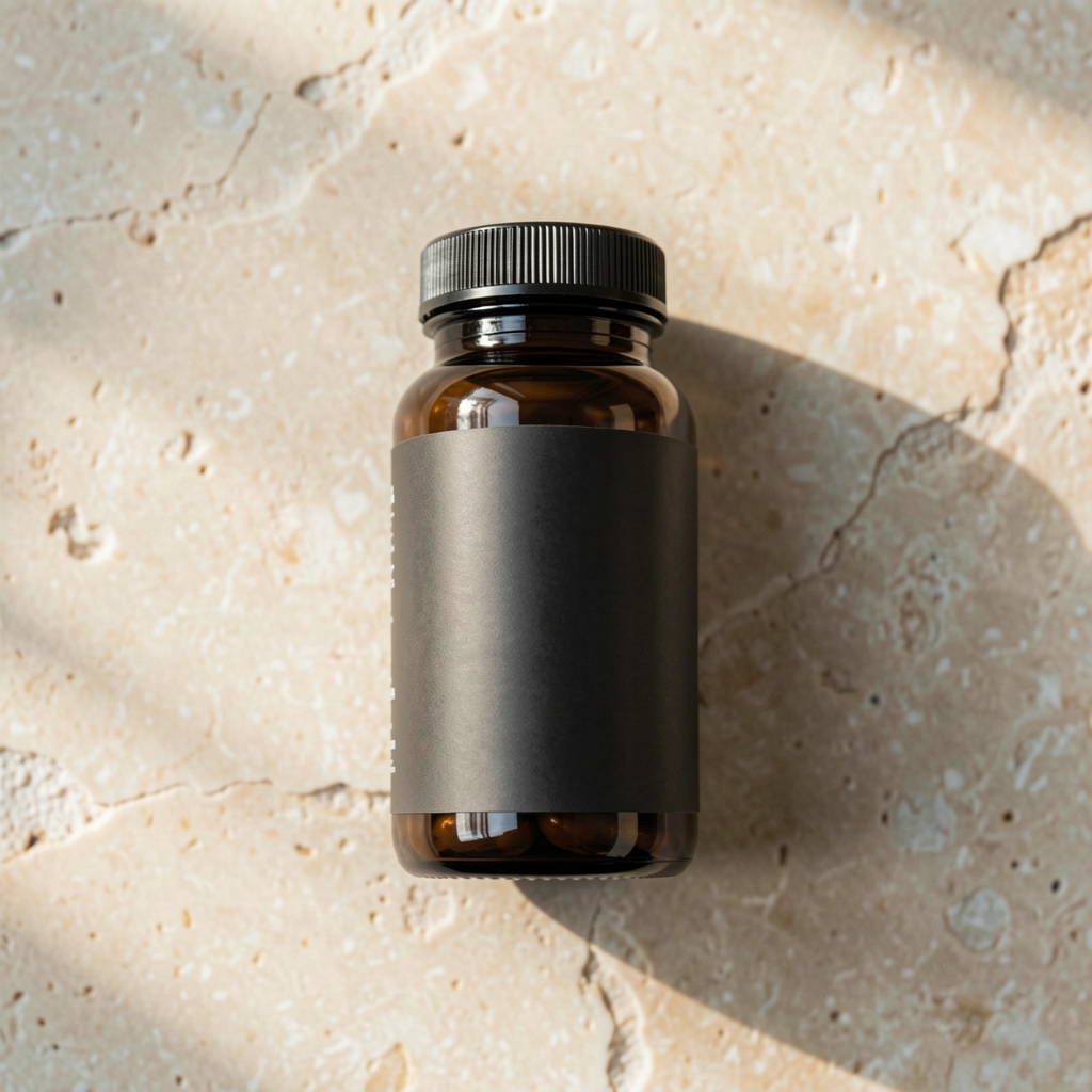 Single dark bottle of daily health supplements on pale stone background, natural side light, overhead editorial photograph